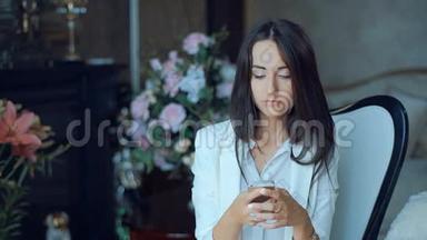 一个女人用智能手机发短信，坐在室内客厅的椅子上