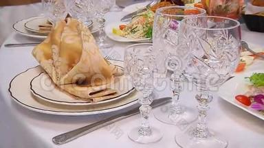 装饰精美的餐桌，配有鲜花、蜡烛、盘子和婚礼或其他活动的服务