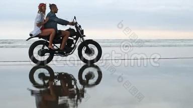 年轻漂亮的夫妇潮人骑复古摩托车在海滩上，户外肖像，骑男女，旅行