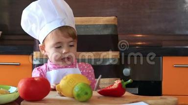 可爱的小宝宝装扮成厨师，这幅可爱的肖像画帮助妈妈准备沙拉