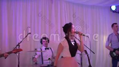 这位年轻歌手在节日表演。 那个女孩在婚礼上唱歌。 在活动中表演摇滚组。