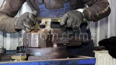 机械手在车库用锉刀研磨生锈的金属。