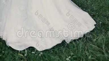 结婚礼服。 新娘在草地上散步