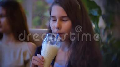 女孩喝奶昔坐在咖啡馆慢动作视频咖啡馆