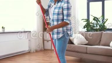 女人用扫把刷洗地板