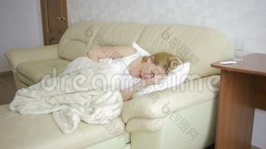 腹痛的女人躺在沙发上。 女孩喝止痛药
