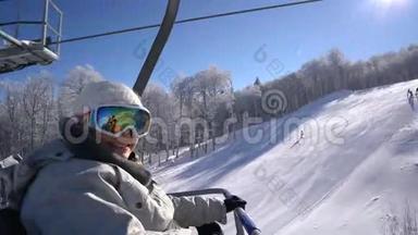 快乐的滑雪者女人站在电梯上爬到山顶