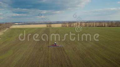 春日下的蓝天绿野.. 拖拉机处理下面的土壤，如画的空中视频