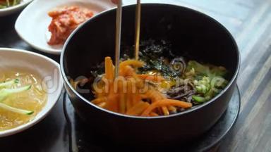 用筷子吃传统的韩国菜Bibimbap。 亚洲正宗美食