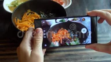用手机拍摄韩国传统菜肴Bibimbap和小配菜clled banchan的食物照片