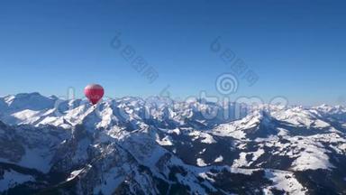 一个热气球在雪上飞行，覆盖了瑞士中部高山高峰。
