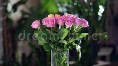 花束在光线的照射下，旋转，花的组成由粉红色和橙色的玫瑰水组成。 在