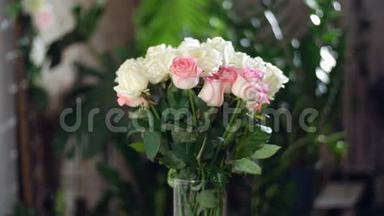 花束在<strong>光线</strong>的照射下，旋转，花的组成由白色和粉<strong>红色</strong>的玫瑰组成。 玫瑰d zhemja