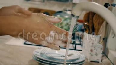 女人在厨房里用肥皂洗手。 带有侧面摄像机运动的特写镜头