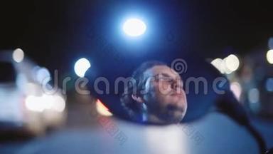年轻英俊的极端男子驾驶摩托车在夜晚反射在镜子上模糊的薄光夜美丽