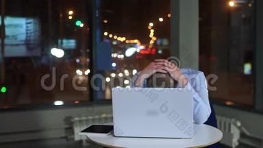 疲惫的商人<strong>深夜工作</strong>，办公室里拿着笔记本电脑。
