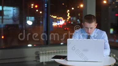 疲惫的商人<strong>深夜工作</strong>，办公室里拿着笔记本电脑。