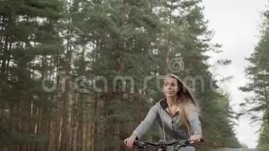 一个穿灰色<strong>运动服</strong>的金发女郎骑自行车。 一个穿灰色<strong>运动服</strong>的金发女郎骑自行车。