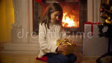 可爱的女孩穿着毛衣打开神奇的圣诞礼盒。 光和火花从盒子里飞出