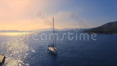 日落在一个空旷的希腊码头，美沙纳，地中海。航空视频拍摄，一艘单独的帆船