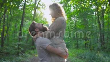 有胡子的年轻人在树林里拥抱他的女朋友