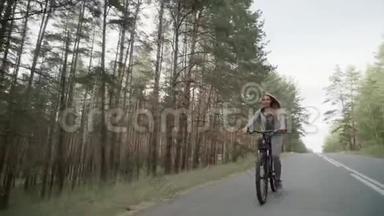 一个穿灰色运动服的金发女郎骑自行车。 一个穿灰色运动服的金发女郎骑自行车。