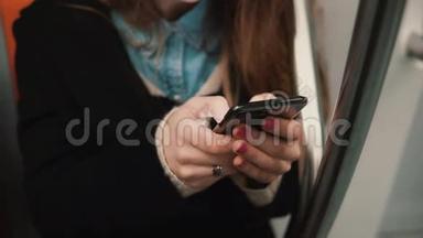 近距离观看女子手拿智能手机，坐在公共交通工具。 女孩用触摸屏上网。