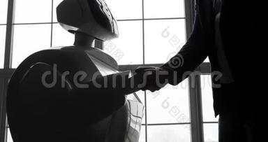 一个时尚的男人与机器人交流，把一只塑料机械手臂按在机器人身上，握手。 控制系统