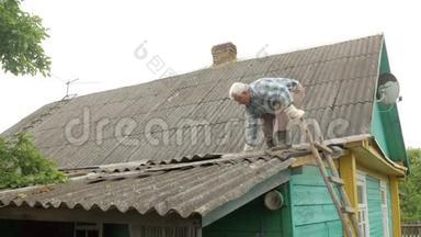 一位老人正在自己修屋顶. 石板上的旧木屋