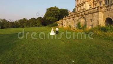 鸟瞰图：一对新婚夫妇走在古堡前的背影。4公里