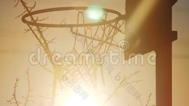 繁华剪影日出日落都市篮球圈.. 从下往上看。 旧的篮球阳光篮圈