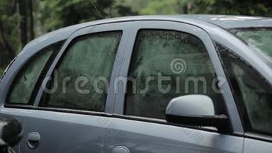 雨点落在汽车侧面、车顶和玻璃上。雾状玻璃
