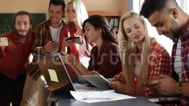 学生使用手机坐课桌大学教室人群微笑