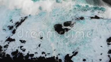 大西洋的海浪拍打着岩石海岸，黑色的火山沙和从上面俯瞰海滩的景色。海浪绿松石，大型