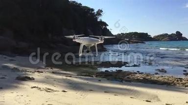 白色四重直升机无人机在海滩上飞行。 西米兰，泰国。 高清慢镜头。