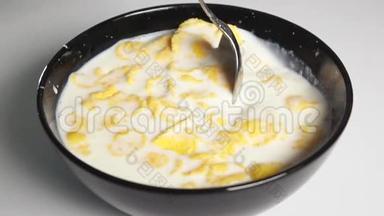 用勺子把玉米片混合在牛奶里