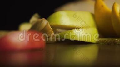 黑色背景下的新鲜水果。 新鲜，美味的切片水果落在桌子上的黑色背景，概念：