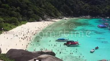 海滩场景充满了快艇乘客游泳，日光浴和享受蓝色的水。 泰国西米兰岛。