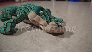 玩具绿鳄鱼躺在地板上