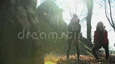 两个女人用慢镜头把树叶抛向空中