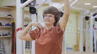 老年妇女伸展身体，在健身室做理疗。 健康体操。 活跃的老年人。