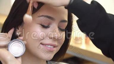专业化妆师将化妆品涂在可爱的少女脸上，用于皮肤护理和健康肤色