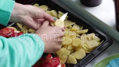 一个女人在烤盘上<strong>切土豆</strong>。