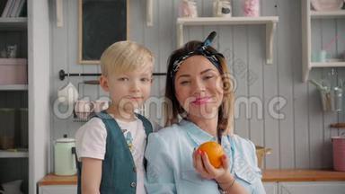 快乐的<strong>妈妈</strong>和小儿子在厨房里，快乐的时光和相聚，<strong>妈妈抱</strong>着新鲜的橘子
