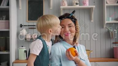 快乐的妈妈和小儿子在厨房里，快乐的时光和<strong>相聚</strong>，妈妈抱着新鲜的橘子