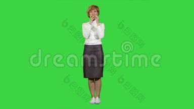 美丽的年轻女子在绿色屏幕上吃苹果，铬键