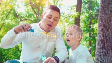 父亲和儿子吹肥皂泡，家庭娱乐，孩子和父亲玩得开心