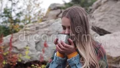 游客在山上喝一杯热水瓶里的茶
