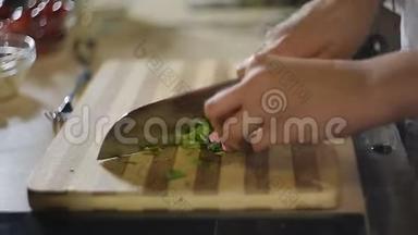 女人手在砧板上切绿色蔬菜沙拉，素食