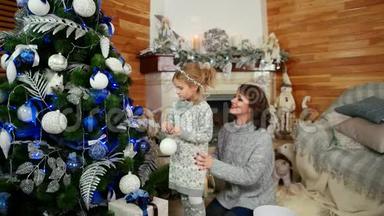 一家人装饰一棵圣诞树，母女正准备过新年，幸福的一家人在